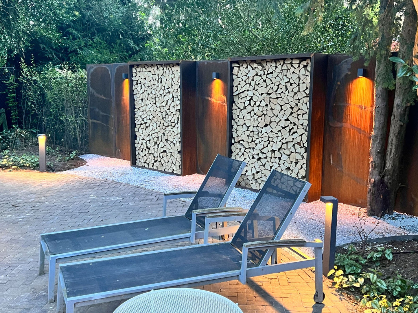 Houtoplagen in cortenstaal in moderne tuin