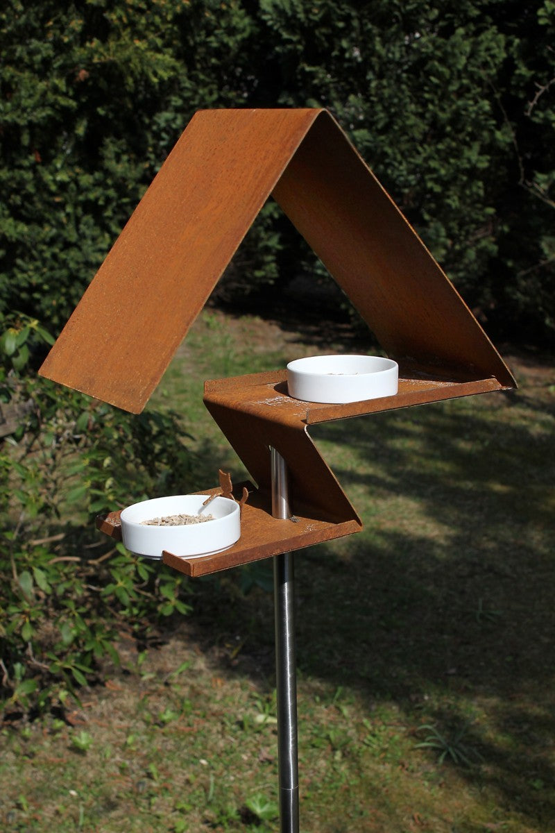 Design vogelhuis in roestkleurig cortenstaal met porseleinen schaaltjes