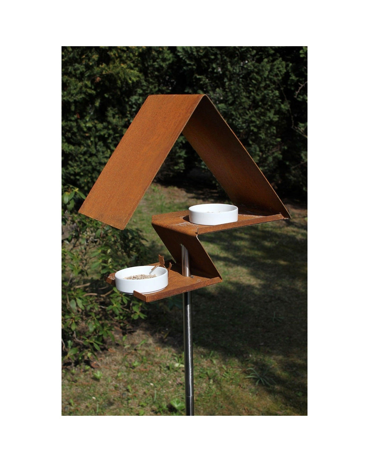 Design vogelhuis in roestkleurig cortenstaal met porseleinen schaaltjes